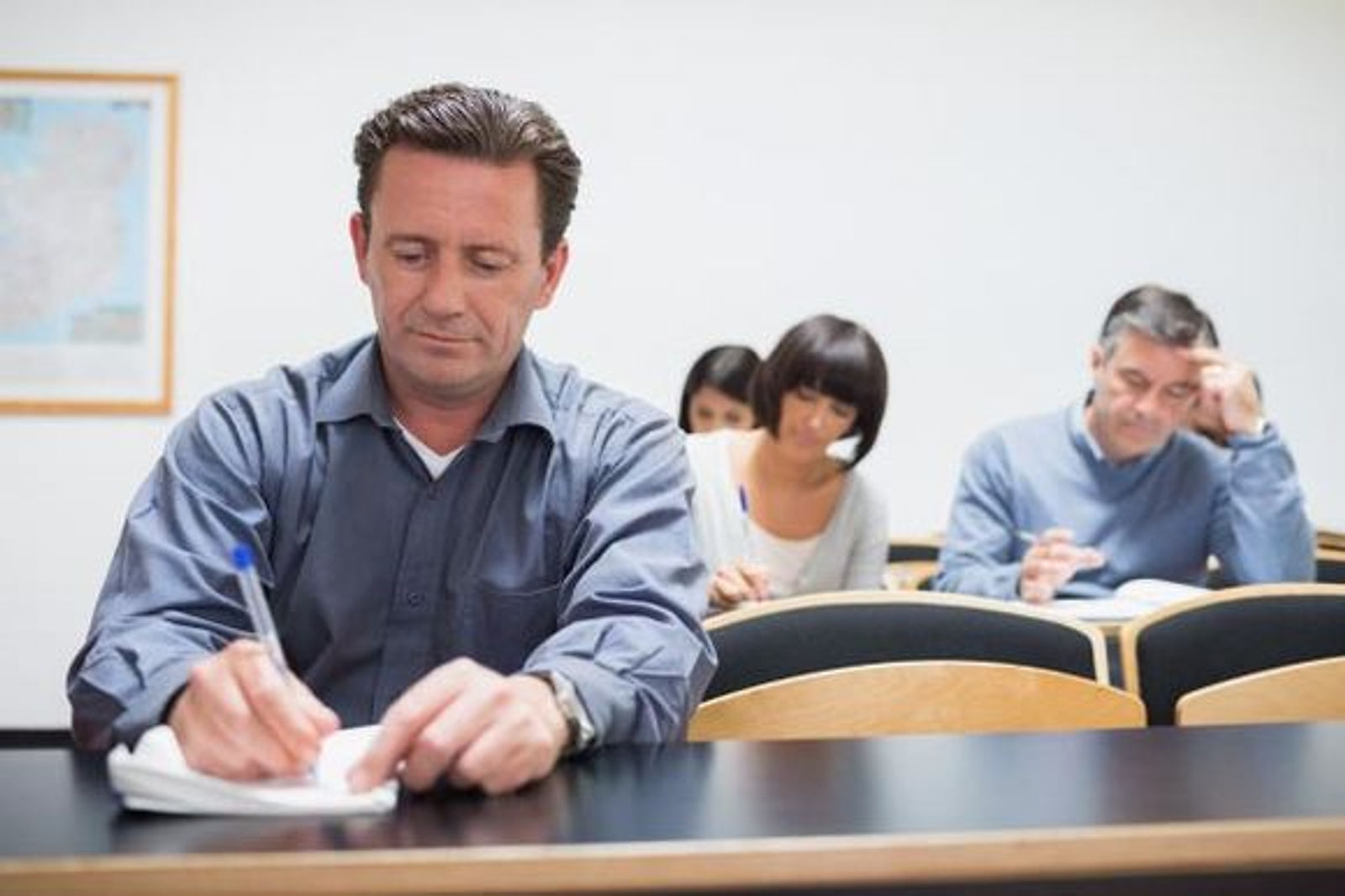 Adultes prenant des notes dans leur livre